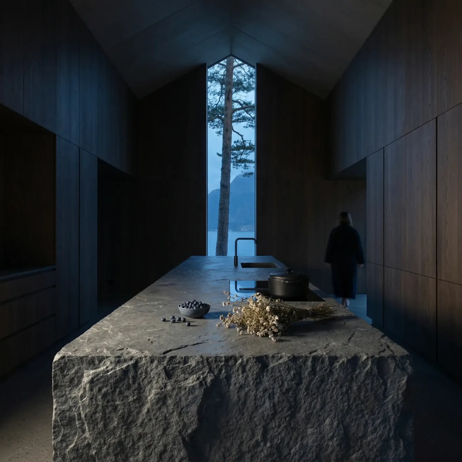 Minimal kitchen with a rough stone island and a narrow vertical window onto the Lofoten landscape