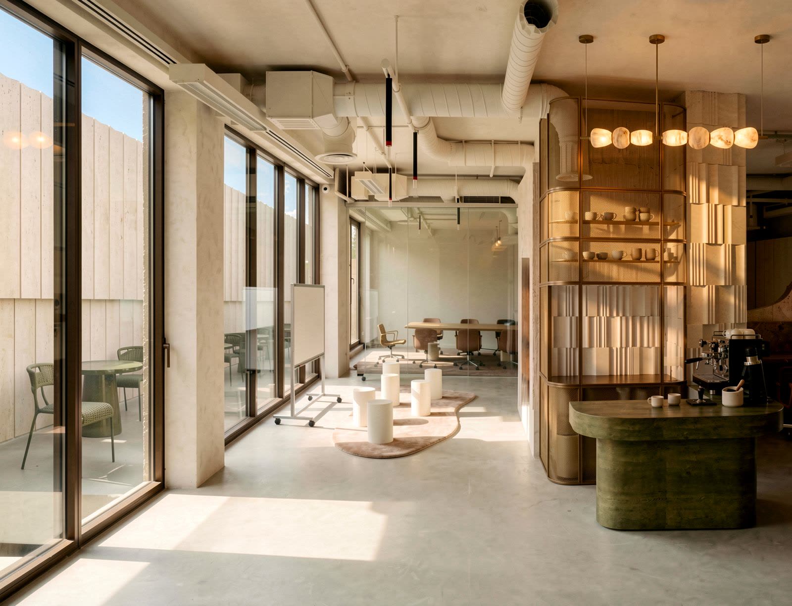 Warm-toned workplace lounge with travertine walls, brass shelving and a coffee counter, visualised by third floor